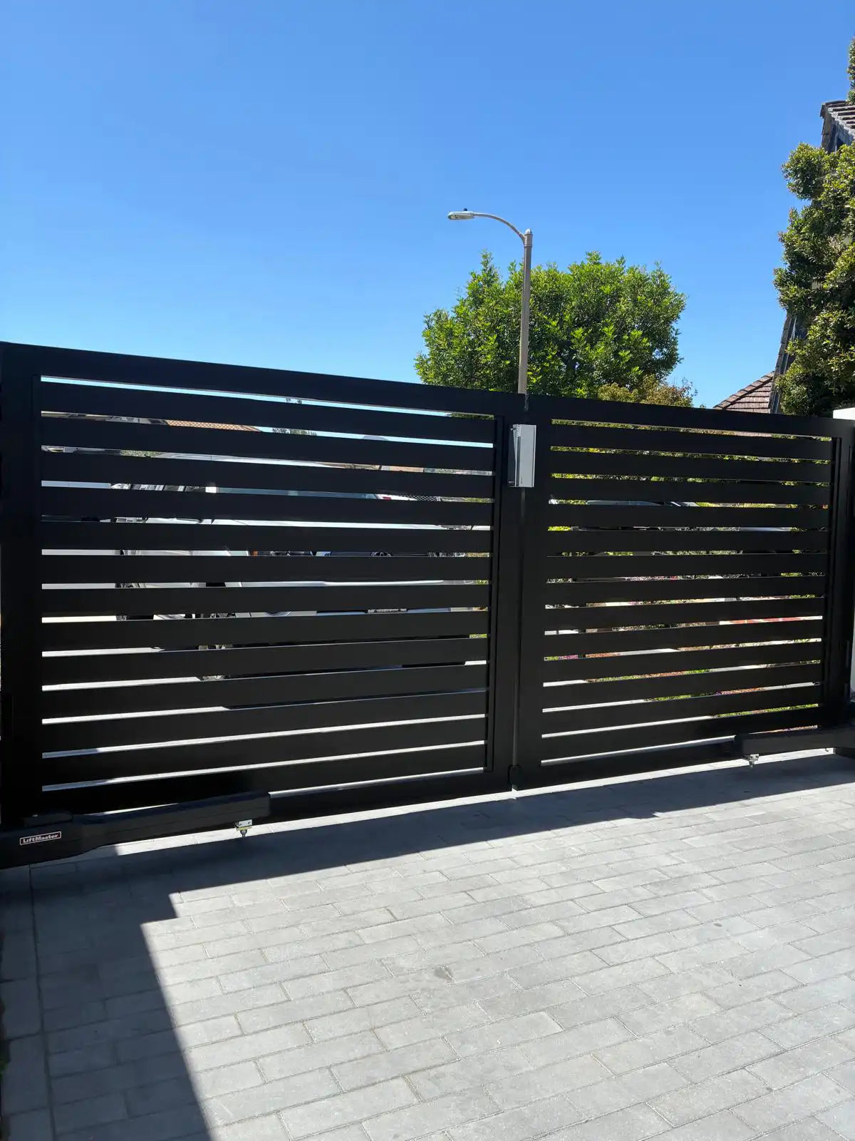 Driveway gate built with long black ALU 40 aluminum slats
