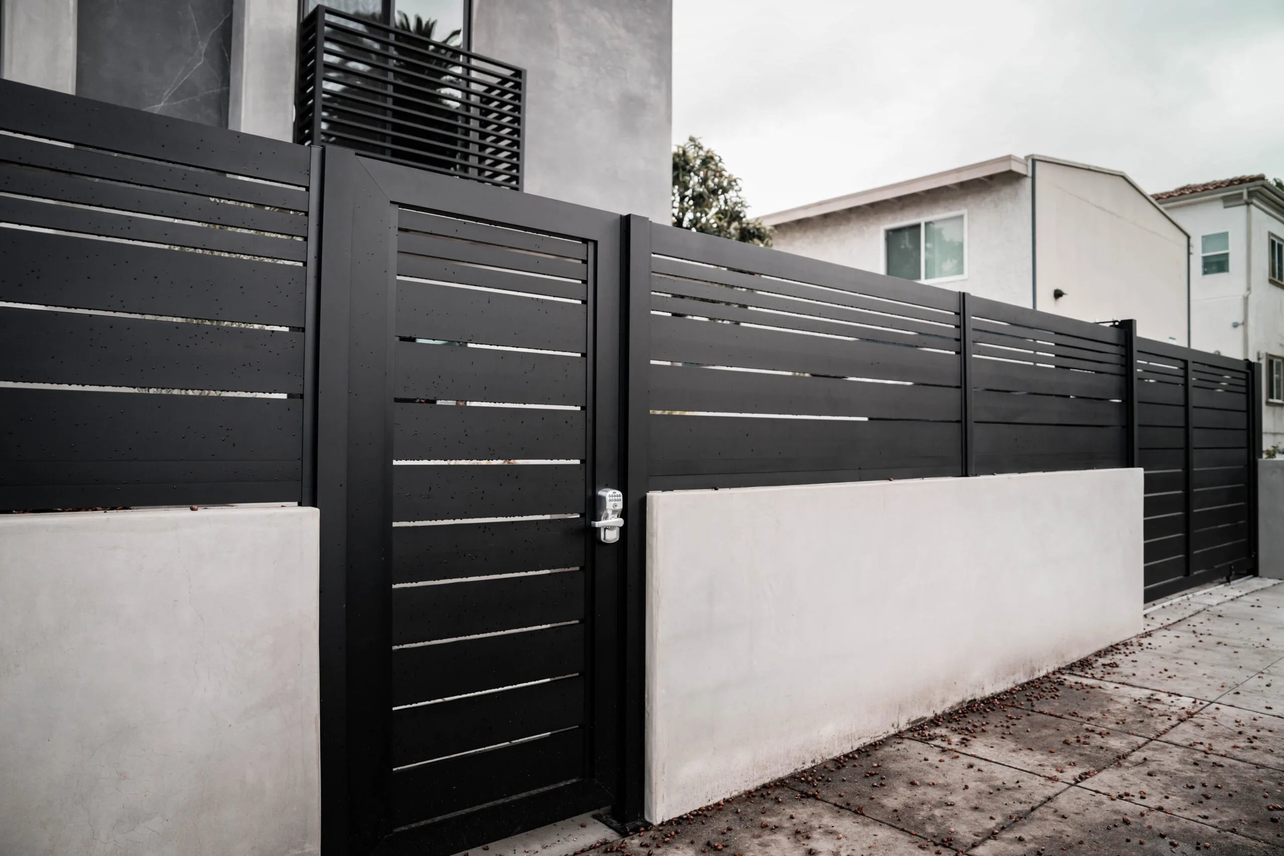 Installed black horizontal aluminum fence and matching pedestrian gate by Aluglobus