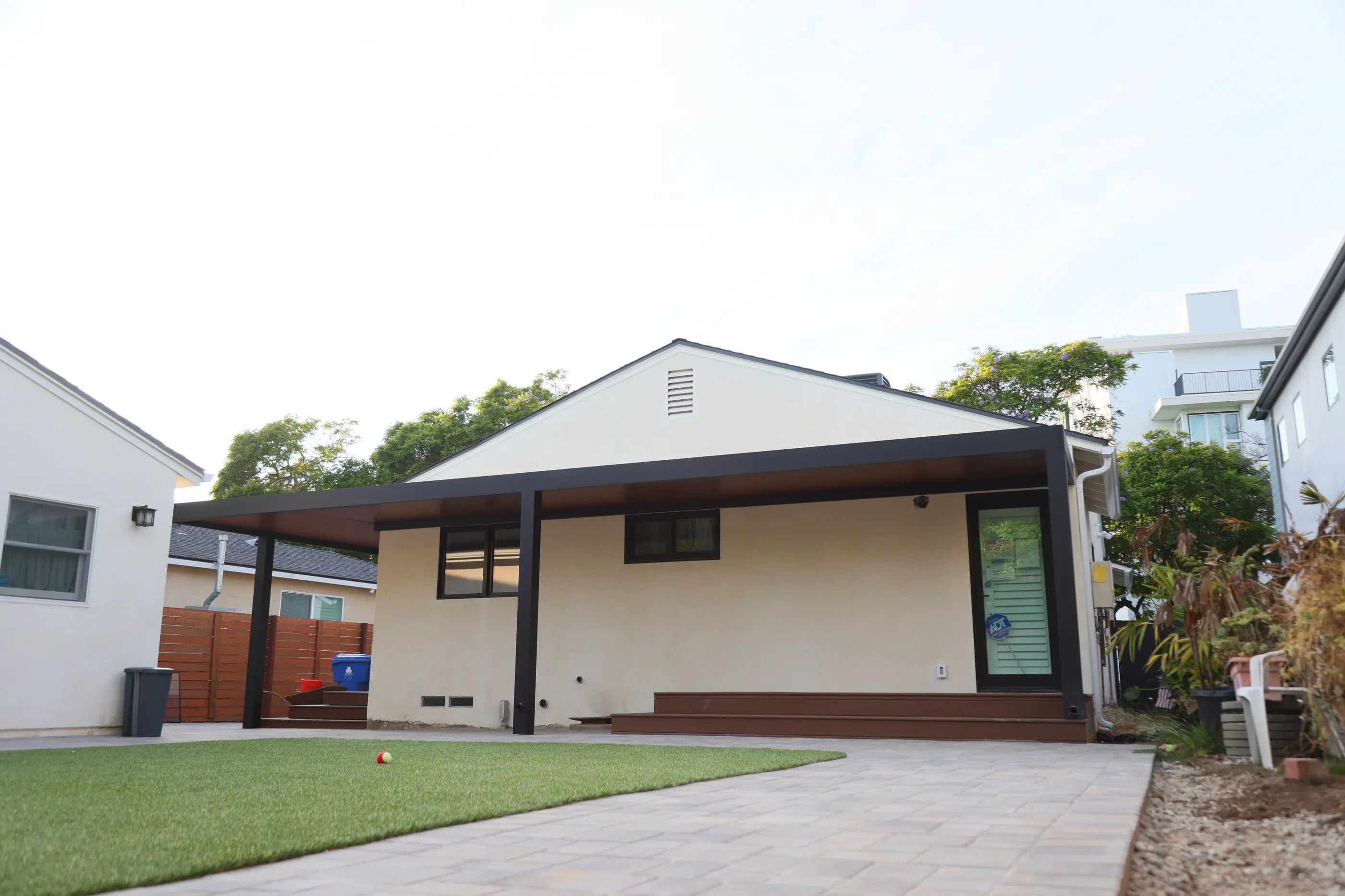 Wide completed insulated aluminum patio cover with a clean white perimeter beam and wood-look ceiling